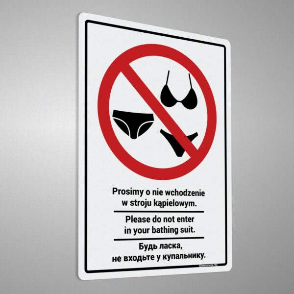 Naklejka z komunikatem w języku polskim, angielskim i ukraińskim „Prosimy o nie wchodzenie w stroju kąpielowym. Please do not enter in your bathing suit. Будь ласка, не входьте у купальнику.”